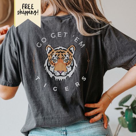 "Easy Tiger! Make an entrance with this two sided graphic tiger crewneck Sweatshirt.  \"ROAR\" on the front left chest. \"GO GET 'EM TIGER\" on the back. GO GET 'EM Tigers Two Sided Comfort Colors Tshirt, Tiger Shirt, Roar, Tiger Mascot, Mascot, Go Tigers, Tiger Shirt, Double Sided, Game Day 🐅 There are several other variations of the Tiger Mascot shirt available in my shop! Take a look! 🤍FREE SHIPPING! 🤍Comfort Colors tees are trendy, garment-dyed t-shirts made 100% with ring-spun cotton. The soft-washed fabric brings extra coziness to your wardrobe while the relaxed fit makes it an excellent daily choice. 🤍Shop Policies: As our items are made to order, we can not accept returns of any kind unless there is a printing or quality issue. All refund or reprint requests must be made within Go Get Em Tiger, Tiger Mascot, Go Tigers, Tiger Shirt, Comfort Colors Tshirt, Easy Tiger, Tiger T Shirt, Spirit Wear, Comfort Colors Tee