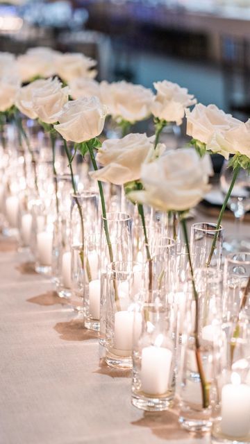 SF Bay Area Florist on Instagram: "Sometimes all you need is candlelight and bud vases 🤍 simplicity and gorgeous 🖤 @plantobewowed @jbjpictures @icmarkhopkins @unionstreetpapery @napavalleylinens #lcfloral #weddingflorist #californiaweddingflorist #winecountrywedding #napawedding #reels #reelsoftheday #floraldesign #chandelierdesign #fineartphotography #creativelywed #napavalleywedding #winecoutry #sfwedding #sfluxuryflorist" White Rose Candle Centerpiece Wedding, Roses In Bud Vases Wedding, White Roses In Bud Vases, White Rose Decor Wedding, White Roses Bud Vases, Wedding Flowers With Candles, 3 Candle Centerpieces Wedding, White Rose Bud Vase Wedding, Candle And Bud Vase Centerpiece Wedding