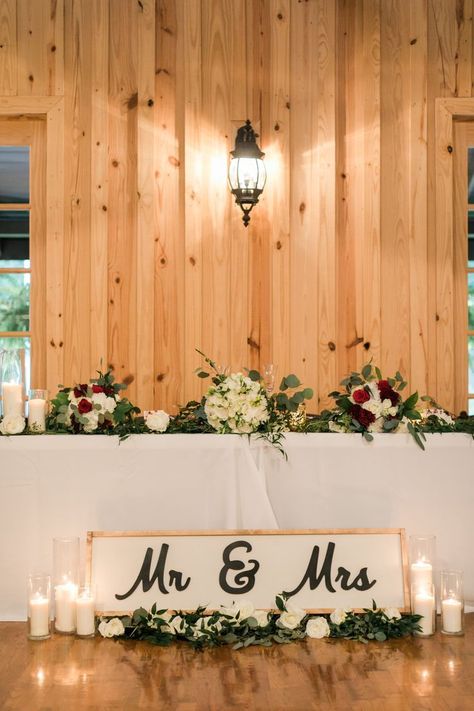 | maroon + white wedding flowers | head table wedding decorations | modern rustic wedding decorations | farmhouse wedding reception decorations | farmhouse wedding head table decor | farmhouse wedding sweetheart table | photo taken at THE SPRINGS Event Venue. follow this pin to our website for more information, or to book your free tour! SPRINGS location: The Ranch in Denton, TX photographer:  Kylie Crump Photography #weddingflowers #weddingreception #farmhousewedding #headtable #sweethearttable Wedding Head Table Decor, Wedding Reception Head Table, Ranch Style Weddings, Head Table Wedding Decorations, Wedding Head Table, Head Table Decor, Head Table Wedding, Sweetheart Table Wedding, Rustic Modern Wedding