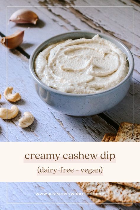 The pin shows an image of the creamy cashew dip in a light grey speckled bowl, sitting on a blue-grey wood background with garlic cloves, cashews and crackers scattered around. The text reads 'creamy cashew dip (dairy-free + vegan)' alongside the website 'www.justsimplywholesome.com'. Cashew Dip, Weekend Meal Prep, Cashew Cheese, Pantry Staples, Cheese Dip, Vegan Recipe, Nutritional Yeast, Family Friendly Meals, Dip Recipes