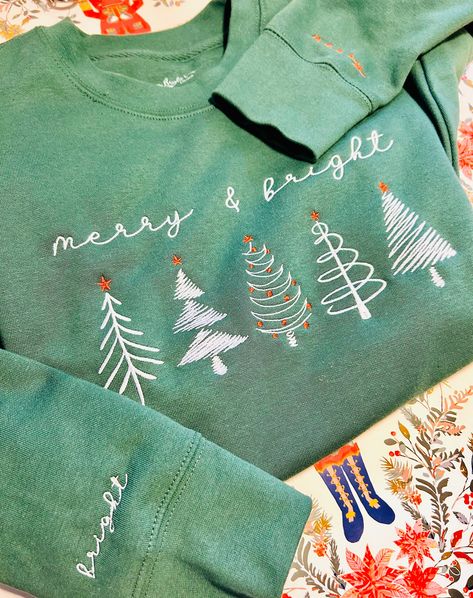 "Elevated your holiday wardrobe with embroidered sweatshirt! Embroidered minimalist Christmas Trees on front chest of the shirt, left wrist is embroidered with the word \"merry\", right wrist is embroidered with the word \"bright\".  Perfect for gifting, family matching, or holiday party. --------------------------------------------------------------------------------------------------------------------------------------- Rock a classic sweatshirt silhouette with ribbed crew neck, long sleeve cu Embroidery Christmas Tree, Xmas Party Outfits, Minimalist Christmas Tree, Sweatshirt Embroidery, Embroidered Christmas, Embroidery Christmas, Christmas Tree Shirt, Matching Sweatshirts, Winter Shirts