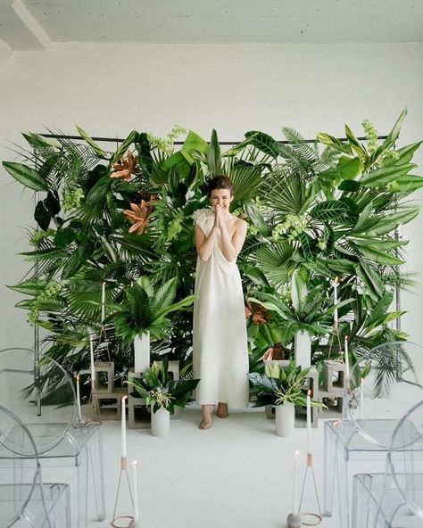 For something tropical with a modern, edgier twist, we love this ceremony backdrop constructed from loads of verdant tropical foliage. Concrete cinderblocks at the base display taper candles while the translucent ghost chairs round out this modern ceremony look. Wedding Walls, Wedding Fest, Laos Wedding, Philippine Wedding, Aisle Decorations, Photo Booth Backdrop Wedding, Booth Backdrops, Rustic Wedding Decorations, Fiesta Tropical