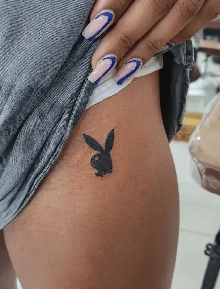 Cute and fierce Playboy Bunny tattoo ideas to channel your inner hustler! Find inspiration for your next ink with these creative designs. #playboy #tattooideas #bunnygirltattoo #innerhustler Cool Tattoo Ideas For Men, Bunny Tattoo Ideas, Playboy Bunny Tattoo, Playboy Tattoo, Cool Tattoo Ideas, Fierce Tattoo, Bunny Tattoo, Basic Tattoos, Boho Tattoos