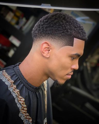 Bring out the natural texture of your curls with a cropped top and mid taper fade. This hair style not only embraces the unique texture of curly hair but also showcases a youthful vibe, making it a popular and fashionable option for black boys seeking a modern and personalized haircut. Black Man Bun With Fade, Black Fades Men, Black Male Hairstyles Fade, Men’s Haircut Taper Fade, Black Hair Cuts Men Taper, Taper Fade Haircut Black Short Hair, Ninja Low Taper Fade, Taper Fade With Short Hair, Mid Afro Taper