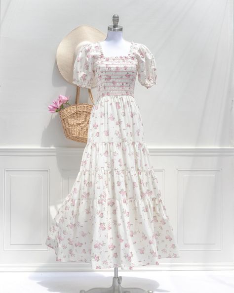 A stunning floral maxi, the In Bloom Dress features a beautful pink floral print on cream cotton, breezy full skirt, square neckline, puffed sleeves, and a smocked elastic bodice for a comfortable, flattering fit. Pair it with a woven sunhat for a romantic summertime look! Pictured with the Betsy midi in pink 🎀 Bloom Dress, International Gifts, Expensive Clothes, Pink Floral Print, Vintage Victorian, Puffed Sleeves, Floral Maxi, In Bloom, Full Skirt