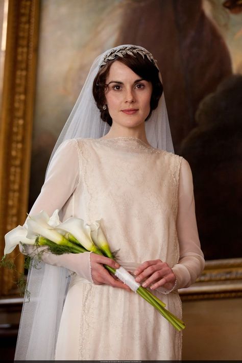 Ah, the royals!  Lady Mary carried a simple bouquet of several long-stemmed white Calla lilies with greenery, tied together with white ribbon and pearl-headed pins. Any florist should be able to create a similar arrangement for you, and DIY brides can also put it together quite easily the morning of their wedding. Downton Abbey Characters, Downton Abbey Wedding, Lady Mary Crawley, Downton Abbey Series, Bridal Crown Tiara, Downton Abbey Fashion, Downton Abby, Michelle Dockery, Lady Mary