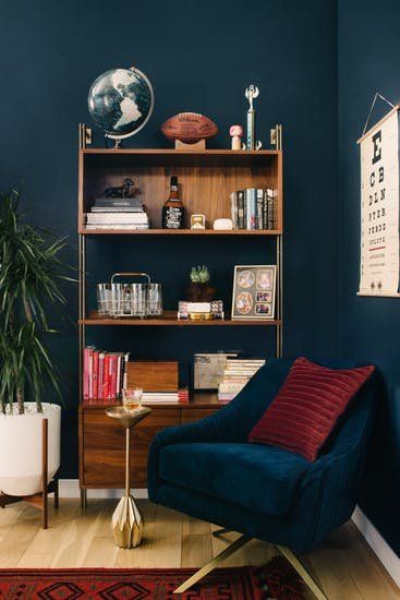 Let this mid-century modern decor in this LA home inspire your next home makeover. Eames Recliner, La Apartment, Guest Room Bed, Navy Paint, Moody Blues, Bachelor Pad, Dark Interiors, Mid Century Modern Decor, Leather Sectional