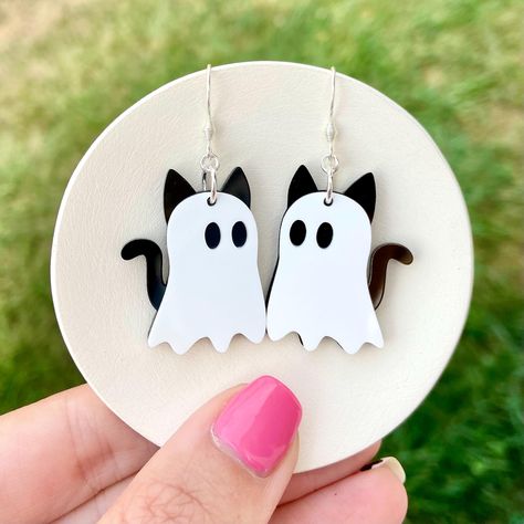 These cat ghost earrings are perfect for Halloween and spooky season. They are hypoallergenic and lightweight. SIZING: Earrings are approximately 1 inch wide & 1 1/4 inches long. Drop length is approximately 1 7/8 inches.  MATERIALS: Silver stainless steel earring hooks are hypoallergenic. Jump rings are sterling silver. Earrings are made of acrylic.  PACKAGING: Earrings arrive in a cotton filled swirl white jewelry box gift case. Perfect for gift giving! SHIPPING: All orders are shipped in 1-5 Clay Drop Earrings, Polymer Halloween Earrings, Spooky Earrings, Earrings Packaging, Acrylic Jewelry, Fall Acrylic Earrings, Halloween Acrylic Earrings, Halloween Cat Clay Earrings, Cat Halloween Earrings