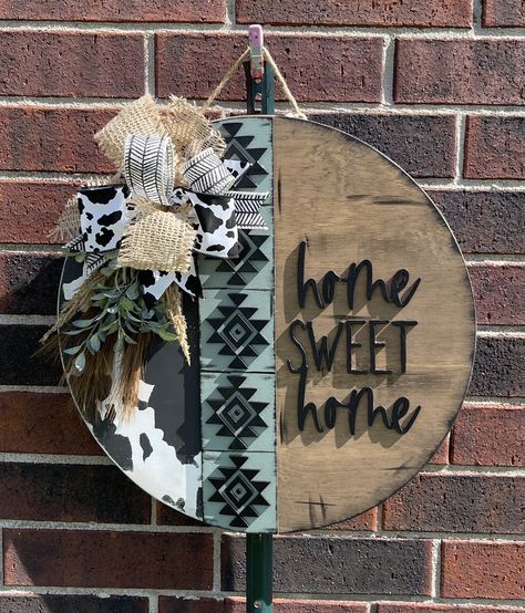 Western Aztec round door hanger.  Who doesn't love a cute western style?  This cute door hanger will welcome your guests and show off your western style.  SIZE:  This sign is an 18-inch wood round door hanger. Thickness is 1/2 inch. WOOD:  This door hanger is made from real birch wood. There may natural blemishes, wood grain and knots since it is real wood. This allows for the character of the wood to shine.  DESIGN:  This wood round is hand painted and stained  and may be distressed.  The wording and Aztec strip is laser cut wood about 3mm thick and adhered with wood glue and may have small nail brads to hold them. The final touches are a wired ribbon bow and greenery. (Ribbon may vary slightly, depending on availability) It comes ready to hang with a jute rope.  FINISHING TOUCH: This doo Gnome Front Door Sign, Checkered Door Hanger, Western Wooden Signs, Leopard Print Door Hanger, Western Door Hangers, Diy Wood Craft Ideas, Wood Porch Signs, Round Welcome Signs, Wood Circle Door Hanger