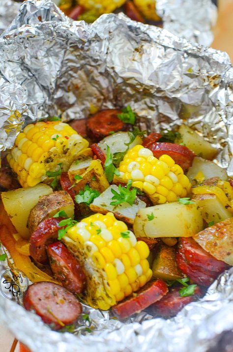 These sausage foil packets are bundles of deliciousness! Pieces of corn, potatoes, onions and of course, sausage, make dinner time a breeze - and with easy cleanup! Potato Foil Packets, Tin Foil Dinners, Foil Packet Potatoes, Foil Pack Dinners, Foil Packet Dinners, Foil Dinners, Foil Pack Meals, Foil Packet Meals, Potatoes Onions