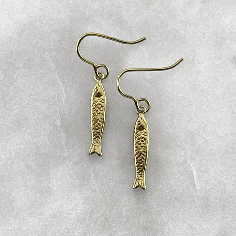 A fish symbolizes fertility, feelings, creativity, rebirth, good luck, transformation, health, abundance, serenity, intelligence, happiness, strength, and endurance. Connecting us with the water element, it represents the deeper awareness of the unconsciousness or higher self. Gold plated solid 925 sterling silver or 925 sterling silver fish hook earrings. Fish measures 2cm in length. Material : Sterling Silver, 24k Gold Plate. Each piece is handmade to order in the Jewel Thief Brighton atelier. Gold Earrings Delicate, Gold Fish Earrings, Fish Earrings Gold, Funky Gold Earrings, Fish Earing, Sardine Earrings, Water Earring, Health Abundance, Gold Fish Necklace