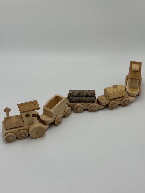 All aboard! This beautifully handcrafted wooden train set is the perfect toy to spark your child's imagination and creativity. Designed with care and attention to detail, this charming train set is made from high-quality, natural wood, ensuring it's as durable as it is delightful. The set includes a locomotive engine and four distinct train cars, each crafted with smooth, rounded edges to ensure safe play for little hands. The natural wood finish highlights the unique grain and texture of the wood, making each piece truly one-of-a-kind. This timeless toy is perfect for kids who love to build, push, and create their own adventures. Ideal for toddlers and young children, this wooden train set is not only a fun plaything but also a beautiful piece of craftsmanship that can be passed down thro Wood Baby Toys, Natural Wood Toys, Locomotive Engine, Wood Train, Train Cars, Wooden Train Set, Craft Booth Displays, Wooden Train, Craft Booth