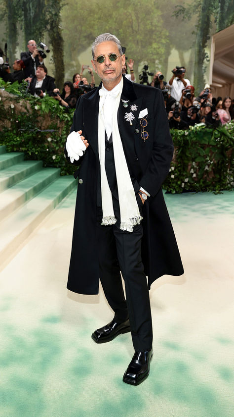 Jeff Goldblum attending the 2024 Costume Institute Gala “The Garden of Time” at the Metropolitan Museum of Art.  Jeff Goldblum wore a black wool single breasted shawl collar tuxedo, white poplin shirt with bow detail, black double breasted wool coat, finished with black shoes.  #PradaPeople #JeffGoldblum #MetGala Jeff Goldblum Outfit, Tuxedo White, White Poplin Shirt, Shawl Collar Tuxedo, Met Gala Outfits, Jeff Goldblum, Gala Outfit, Costume Institute, Poplin Shirt