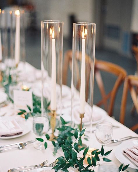 I love the use of hurricane glass with tapered candles Sun Wedding, Taper Candles Wedding, Gold Taper Candles, Green Centerpieces, Simple Wedding Flowers, Simple Wedding Centerpieces, Candle Wedding Centerpieces, 2025 Wedding, Candles Photography