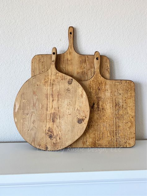 "Set of Three Bread Boards, Medium Rectangle, Small Square, and Small Round Bread Board, French Charcuterie Board, Cheese Board These boards are a lovely primitive addition to display in any rustic kitchen!  Boards were handcrafted, giving each one its character. These were created using reclaimed cheese board wood planks from Holland that were used to dry and age cheese.  We hand scrape the bulky cheese wax off leaving the knife markings, leftover coloration, paint spots, wax residue from the c French Bread Board, Round Bread, Charcuterie Board Cheese, Bread Boards, Board Cheese, Bread Board, Charcuterie Boards, Wood Board, Wood Planks