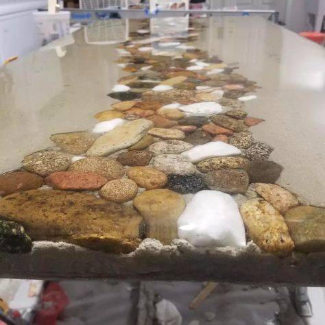 24"x48" concrete river rock table top with a smooth epoxy finish. Natural river rock meets the industrial world. River Rock Countertop, River Rock Backsplash Bathroom, River Rock Shower Floor, Black River Rock Shower Floor, River Rock Wall Interior Pebble Tiles, Pebble Shower Floor River Rocks Rustic, Rock Rings, Easy Wood Projects, Small Wood Projects