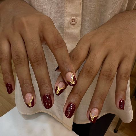 Nails as rich as fine wine, with a touch of gold. 🍷💛 To book your appointment: 🤳Call or WhatsApp at +98670 78427 OR 👩🏻‍💻Book Online 🏷️-red nails, burgundy nails, burgundy wine nails, burgundy and gold nails, nail art, nail extensions, nail goals #AtThePod #TheSugarPod #NaviMumbai #nailartclub #nailgoals #nailextensions #acrylicnails #burgundynails #burgundyandgoldnails #naildesigns #nailartinspo #nailsoftheday Cherry Red Nails With Gold Accents, Burgundy Nails With Gold Flakes, Dark Red Gold Nails, Gold And Burgundy Nails, Nails Burgundy And Gold, Burgundy Gold Nails, Wine And Gold Nails, Gold Burgundy Nails, Burgundy Nails With Gold