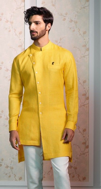 A blend of sublime grace & sophistication, the #Kurta is a timeless menswear classic. Spark the #celebrations with unique Kurtas from the #RaymondCeremonial collection!  The Ensemble: Mustard yellow asymmetric Kurta Pithi Outfit For Groom, Tilak Dress For Men, Haldi Dress For Men Yellow, Kurta Designs Men's, Haldi Ceremony Outfit, Asymmetric Kurta, Yellow Kurti, Haldi Dress, Boys Kurta Design