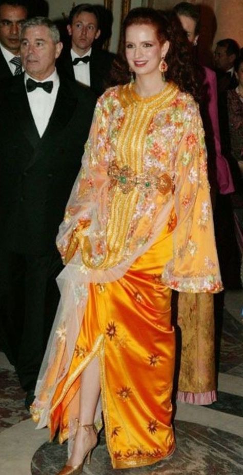 The Mansouria is a traditional Moroccan ensemble consisting of two pieces: an embroidered caftan made of silk or velvet, topped with a transparent overlay known as Mansouria or Dfina. Typically, this sheer overlay matches the color of the caftan. The name "Mansouria" is derived from the 16th-century Saadian Sultan, Ahmed al Mansour, who pioneered the addition of this second layer to the classic Moroccan Caftan. Lala Salma, Moroccan Outfit, Lalla Salma, Royal Hairstyles, Arabic Fashion, Morocco Fashion, Linen Style Fashion, Embroidered Caftan, Moroccan Clothing