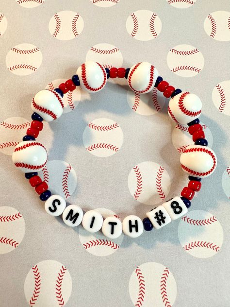 Customize the player or team name and number with this baseball beaded stretch bracelet. Perfect for players and fans!  Bracelets are available in a variety of lengths.  Pick your custom length from the drop down menu below.  Please be aware that beading may slightly differ from what is pictured as to accommodate selected sizing.  All our bracelets are made with quality in mind.  With that being said, all bracelets should be treated with care while putting on, wearing, and taking off.  Keep dry. Sports Mom Bracelet, Baseball Bracelet Diy, Baseball Mom Bracelet, Swiftie Bracelets, Baseball Ideas, Football Jewelry, Baseball Bracelet, Toms River Nj, Homemade Bracelets