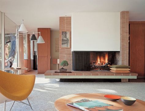 A brick fireplace divides several spaces within the otherwise open-concept floor plan. In the background, floor-to-ceiling mahogany cabinetry creates privacy and a transition along the hallway into the master suite. #dwell #richardneutra #modernhomesforsale #midcenturymodernhomes Neutra House, Mid Century Modern Fireplace, Mid Century Modern Living Room Decor, Casa Retro, Richard Neutra, Mid Century Living, Mid Century Architecture, Mid Century Modern Living, Mid Century Modern Interiors