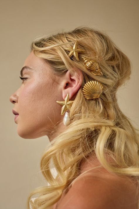 Unleash your inner coastal goddess with our new Serena Shells Clips. These luxe seashell clips will elevate your look, perfect for an elegant and editorial style. Wear them in sets for an editorial touch. Antique 14k gold Made in NYC. Mermaid Flower Crown, Seashell Earrings Aesthetic, Seashell Outfit Aesthetic, Sun Hair Accessories, Sun Hair Clip, Beach Accessories Aesthetic, Shells In Hair, Seashells Accessories, Siren Accessories