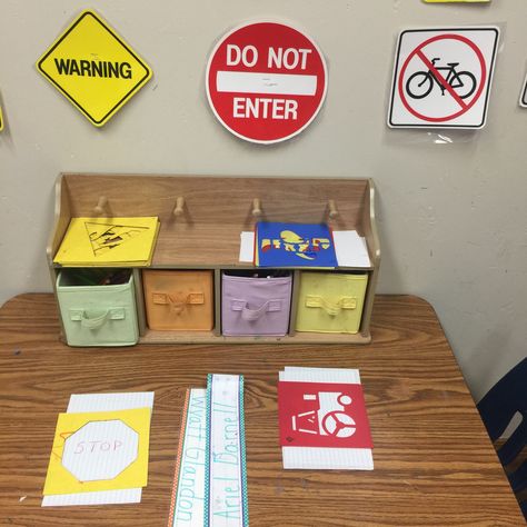 Sign making in preschool writing center for transportation unit. Colored pencils, shape stencil, transportation stencils, and sign decor on wall Signs Unit Preschool, Preschool Writing Center, Environmental Print Activities, Prek Transportation, Environmental Signs, Writing Center Preschool, Pre K Lesson Plans, Creative Curriculum Preschool, Land Transport