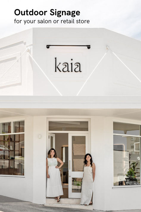 Exterior view of 'Kaia' salon showcasing a minimalist white sign with black lettering mounted on a clean, white facade. Two smiling women stand at the entrance, inviting a warm welcome to clients Japanese Beauty Salon, Dream Hair Salon, Hair Salon Signage, Hairdresser Salon Design, Spa Signage, Hair Spa Salon, Aesthetic Salon, Neon Studio, Spa Interior Design