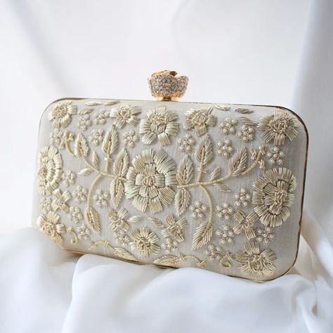 A very classy and regal ivory silk clutch embellished with light gold zardozi and pearls. Also consists of a diamante rose clasp. Super chic! not given not given Silk Silk Clutch, Bridal Handbags, Embellished Clutch, Pearl Accessories, Embroidered Clutch, Potli Bags, Bridal Clutch, Graduation Gifts For Her, Cream Silk