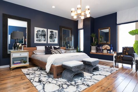 This master bedroom has modern art, a dark wall color, a shag rug and gold accents to create the ultimate resting space. Texture and pattern in rugs, throws and contemporary art add drama. Throw pillows add softness and support. The walls in the bedroom are painted a deep Naval Blue by Sherwin Williams, which gives the interior depth and drama. Walnut wood finishes gives the room a warm glow against the dramatic black and white accents and dark walls for an eclectic feel. Master Room Design, Dark Wood Bed, Navy Bedrooms, Navy Blue Bedrooms, Blue Accent Walls, Eclectic Modern, Bedroom Images, Accent Wall Bedroom, Eclectic Bedroom