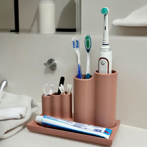 Our sleek and versatile toothbrush stand, designed to elevate the organization and style of your bathroom countertop. Standing at 124 mm tall and 99 mm wide at the base, this sleek accessory seamlessly integrates into any bathroom decor.  This innovative stand features a dedicated tray for holding toothpaste, three separate holders for Q-tips, tweezers, and flossers, and a spacious toothbrush holder that can accommodate up to four toothbrushes or one electric toothbrush along with two standard toothbrushes. Crafted with a minimalist and modern aesthetic, this toothbrush stand seamlessly blends functionality with elegance. Its clean lines and practical design ensure that your bathroom essentials are neatly organized and easily accessible, while the removable cylinders make cleaning a breeze Formal Aesthetic, Counter Organizer, Q Tip Holder, Electric Toothbrush Holder, Counter Organization, Toothbrush Holders, Toothpaste Holder, Bathroom Fittings, Bathroom Countertop