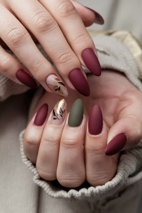 Embrace the season with these elegant matte fall nail ideas that perfectly complement the rich hues of autumn. Imagine deep burgundy and muted mustard shades finished with a velvety matte topcoat, providing a sophisticated touch to your fall style. This nail design is not only trendy but also an expression of warmth and coziness. Don't miss out on these stunning matte fall nail ideas for your next manicure! Oval Nails Designs Matte, Fall Season Nails Matte, Green And Maroon Nails, Autumn Nails Matte, Maroon Fall Nails, Matte Burgundy Nails, Fall Nails Matte, Moody Nails, Dress Trending