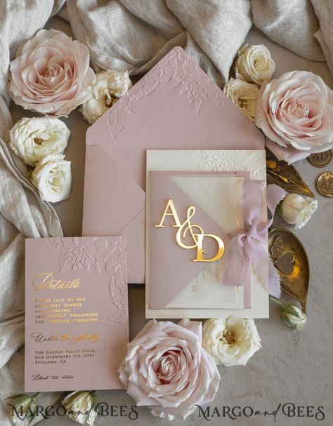 Create an unforgettable first impression with our Blush Gold Wedding Invitation, a design that exudes elegance and timeless beauty. Featuring a delicate chiffon torn bow, this invitation offers a touch of softness and romance that perfectly complements its luxurious gold accents. The highlight is the mirror gold monogram, which adds a modern, reflective element, symbolizing the brilliance of your love story. Wrapped in vellum adorned with golden elegant roses, this invitation showcases an exqui Blush Cream And Gold Wedding, Taupe Wedding Invitations, Champagne Pink Wedding, Pink And Gold Wedding Theme, Hot Pink Wedding Invitations, Gold And Pink Wedding, Taupe Wedding, Romantic Theme Wedding, Elegant Wedding Stationery