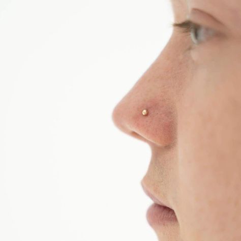 Symbolizing wholeness and completion, the Tiny Secret Stud L-Shape Nose Ring gives you a touch of shine - perfect for minimalists and those who love dainty gold jewelry. Tiny Gold Nose Stud, Small Gold Nose Stud, Gold Nose Piercing Studs, Gold Stud Nose Piercing, Nose Piercing Gold, Piercing Placement, Gold Nose Ring Stud, Gold Nose Piercing, Dream Piercings