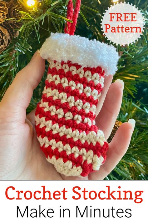 Close up of hand holding a striped crochet mini stocking decoration hanging on Christmas tree Small Crochet Stocking Pattern Free, Crochet Small Christmas Stocking, Mini Crochet Christmas Stocking, Mini Christmas Stockings Crochet, Crochet Stocking Ornament, Mini Crochet Stocking Pattern Free, Crochet Mini Christmas Stocking, Mini Stocking Crochet Pattern, Crochet Mini Stocking Pattern Free