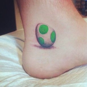 Yoshi’s Egg | 30 Rad Tattoos Inspired By Nintendo Yoshi Tattoo, Easter Bakes, Yoshi Egg, Rad Tattoos, Nintendo Tattoo, Video Game Tattoos, Nerdy Tattoos, Gamer Tattoos, Mommy Tattoos