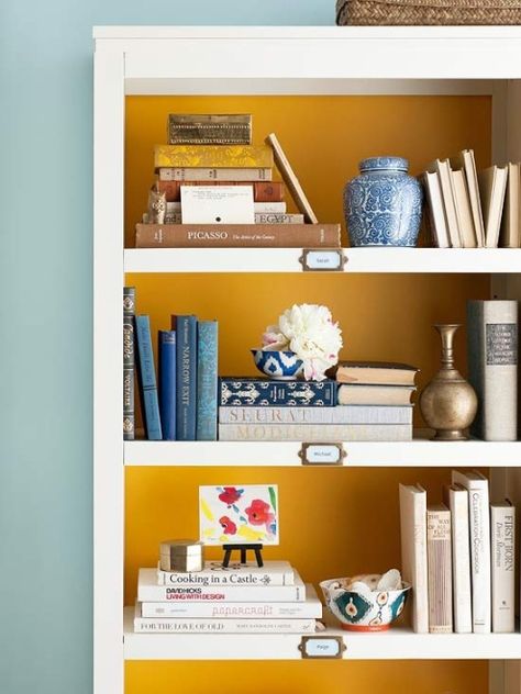 paint the back of a bookcase for a pop of color, love this mustard with the gold labels on the shelves. Red Bedroom Design, Bookcase Styling, Bookshelf Styling, Bedroom Red, Decorating Shelves, Estantes Flotantes, Book Display, Book Shelf, My New Room