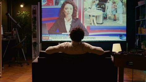 Man in home theatre watching huge TV screen showing news broadcast reportages on family trips. Zoom in shot on cord cutter looking at streaming service travelling channel on widescreen television set Watching Tv Cinematography, People Watching Tv, Tv Reflection, Man Watching Tv, Family Watching Tv, Tv Shooting, Movie Theatre Seats, Huge Tv, Halloween Shoot