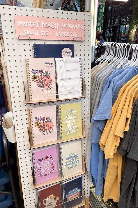 I love how this pegboard came together to display my mental health journals. The pegboard was used to display my journals at eye level and use more vertical space and not a lot of floor space. #craftfair #marketbooth #boothsetup #journaldisplay #notebookdisplay #pegboarddisplay Small Store Display Ideas, Journal Display, Craft Show Booth Display Ideas, Booth Display Ideas, Art Fair Display, Vendor Booth Display, Pegboard Display, Craft Market Display, Craft Show Booth