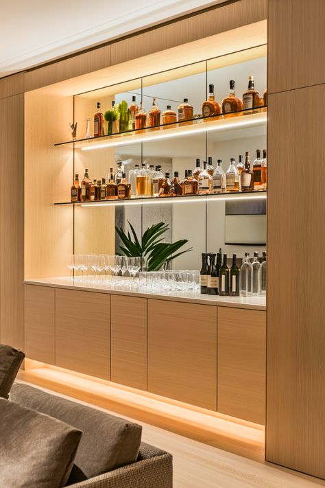 Ever dreamed of a seamless, custom bar setup? Built-in shelves blend effortlessly with your home’s architecture, adding a polished and luxurious touch to your bar area. I’m obsessed with how mirrors and backlighting can highlight your glassware and liquor bottles, creating a chic display. It’s the perfect solution for modern home bars or niche spaces. Ready to create a sleek and sophisticated look in your home? Kitchen With Built In Bar Area, Den Bar Ideas, Home Bar Wall Ideas, Wine And Liquor Wall Rack, Alcohol Display Ideas, Drinks Cabinet Ideas Home Bars, Mini Bar Ideas For Home Living Rooms, Luxury Mini Bar At Home, Bookcase Bar Ideas