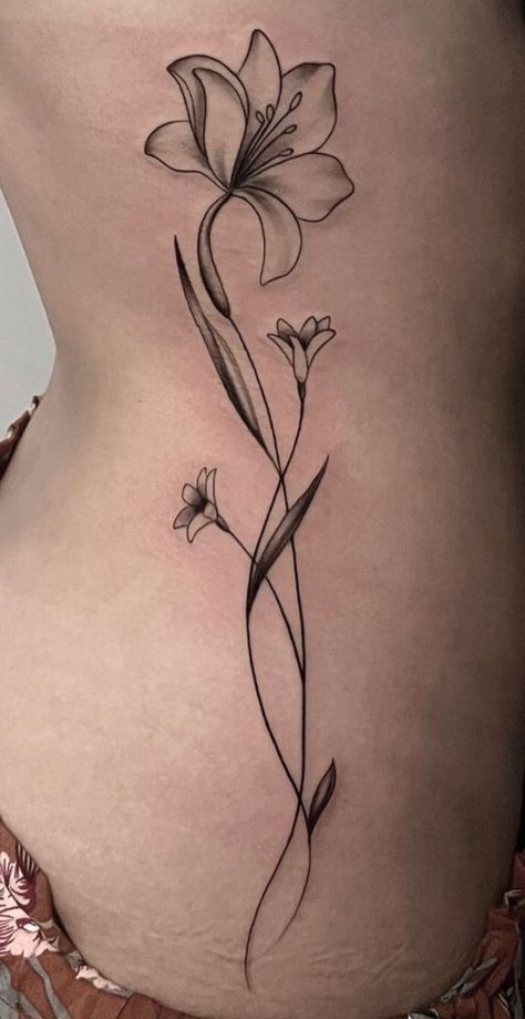 Lily Spine Tattoos For Women, Tulip Hip Tattoo, Lilly Spine Tattoo, Side Of Stomach Tattoo For Women, North Tattoo, Lilly Flower Tattoo, First Tattoo Ideas, Dark Skin Tattoo, Lillies Tattoo