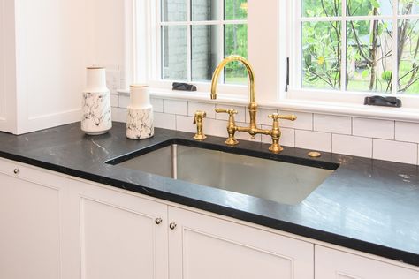 A favorite design element is the unlacquered brass faucet. It pops against the black countertops and white tile backsplash. Woody O’Neal White Sink Black Faucet, White And Brass Kitchen, White Cabinets Black Granite, White Cabinets Black Countertops, Unlacquered Brass Faucet, White Farmhouse Sink, Gold Faucet, White Kitchen Sink, White Tile Backsplash