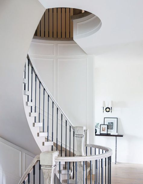 To help offset the expense of the staircase, the underside of the stairwell has no applied moulding. | Photographer: Phil Crozier | Designer: Reena Sotropa & Alanna Dunn, Reena Sotropa In House Design Group Open Curved Staircase, Light Grey Painted Walls, Wood Stair Treads, Oak Handrail, White Living Rooms, Entry Tile, Secret Doors, White Lantern, Handrail Design