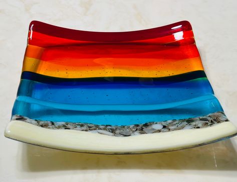 "Fused glass beach sunset plate with French Vanilla for the sand, White and Brown for the rocks by the water, Turquoise and Blue for the ocean waves, and Yellow, Orange, Red sunset skies. This dish has an additional layer of clear glass on the back for a more elegant look and for creating the beautiful bubbles effect. Please note that all my items are Handmade so there may be slight color and / or design variations. A beautiful plate, reminds me of my favorite place to be! Perfect for decorati Fused Glass Sunset, Fused Glass Beach, Beach Dessert, Ocean Soap, Sunset Skies, Fused Glass Dishes, Glass Fusing Projects, Glass Beach, Red Sunset