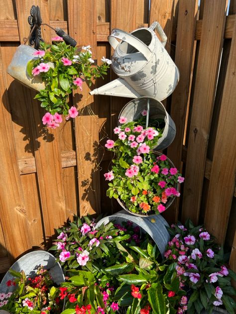 This project turned out perfect! Just grab a bunch of old buckets and drill you some holes and start stacking them on a rod! Oh, and add some fairy lights to your watering can! It looks fantastic at night! 💗🌿🌸 Watering Can With Lights, Old Bucket, Flower Bucket, Water Flowers, Watering Can, Buckets, Fairy Lights, At Night, Tower