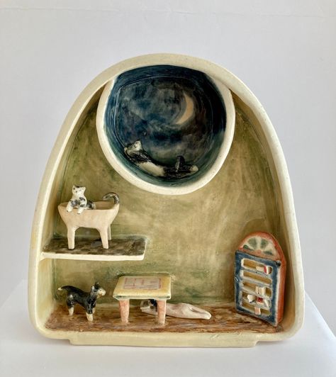 Inspired by Goodnight Moon, this is my second version of Goodnight Cat. It features a skylight nook with a tuxedo cat sleeping under a painted moon, a cat peering over the edge of a bathtub, a Shiba inu dog looking at a little girl who is reading a book under a table. I sculpted and painted this miniature diorama as a vignette to bring a little childhood joy back into the present moment.  You can only display this, standing, on a mantelpiece or bookshelf. It is sculpted and painted with underglazes, and finished with a clear, glossy finish (kiln-fired twice). All of the pieces are fixed in place, not removable.  Size: 6.5" X 2" X 6.5" height Clay Diorama Ideas, Air Dry Clay Diorama, Clay Diorama, Clay Diorama Scene, Cat In Dollhouse, Polymer Clay Sleeping Cat, Cute Cat Ceramic, Good Night Cat, Clay Magnets