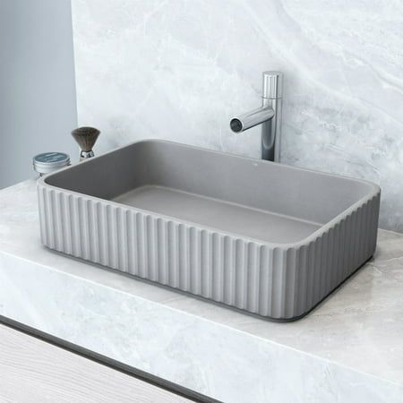 The Windsor Concreto Stone Rectangular Fluted Bathroom Vessel Sink is a breathtaking blend of timeless elegance and modern design. Its exterior reveals an intricate fluted design, adding a touch of artistic allure. Crafted from durable Concreto Stone, a sustainable blend of concrete and natural materials, this sink not only withstands high temperatures but also radiates an eco-conscious vibe. Size: 14'' D, 21'' W, 5'' H.  Color: Gray. Stone Sinks Bathroom, Fluted Bathroom, Stone Bathroom Sink, Stone Sinks, Sinks Bathroom, Stone Sink, Vessel Sink Bathroom, Furniture Details, Bathroom Cabinets