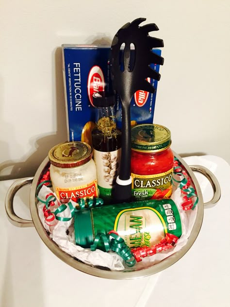 Perfect gift basket for any occasion. Fettuccine pasta, spaghetti pasta, Alfredo sauce, marinara sauce, spiced oil, parmesan cheese, pasta spoon, all inside of a pasta strainer! #christmasgift #giftidea Spaghetti Basket Ideas, Pasta Basket Ideas, Spaghetti Gift Basket Ideas, Pasta Night Basket, Pasta Gift Basket Ideas, Softball Basket, Pasta Gift Basket, Dinner Gift Basket, Tricky Tray