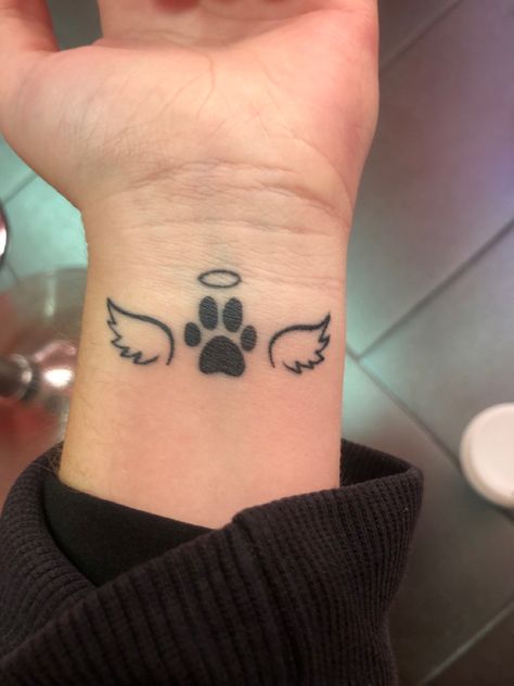 A tattoo with wings a paw print and a halo Paws With Wings Tattoo, Pawprint Tattoo With Halo, Tattoo With Dog Paw Prints, Where To Put Paw Print Tattoo, Dog Paw With Wings Tattoo, Tattoo Ideas Dog In Memory Of Small, Tatoos To Remember Your Dog, Paw With Halo Tattoo, Dog Halo Tattoo