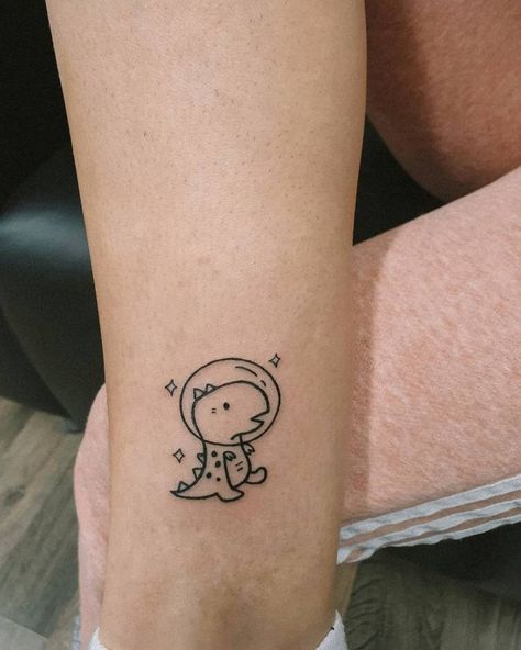 Tattoo Ideas Female Dinosaur, Space Dinosaur Tattoo, Tiny Space Tattoo, Mini Dinosaur Tattoo, Small Dino Tattoos, Dinosaur Tattoos For Women, Small Space Tattoo, Tiny Dinosaur Tattoo, Cute Dinosaur Tattoo